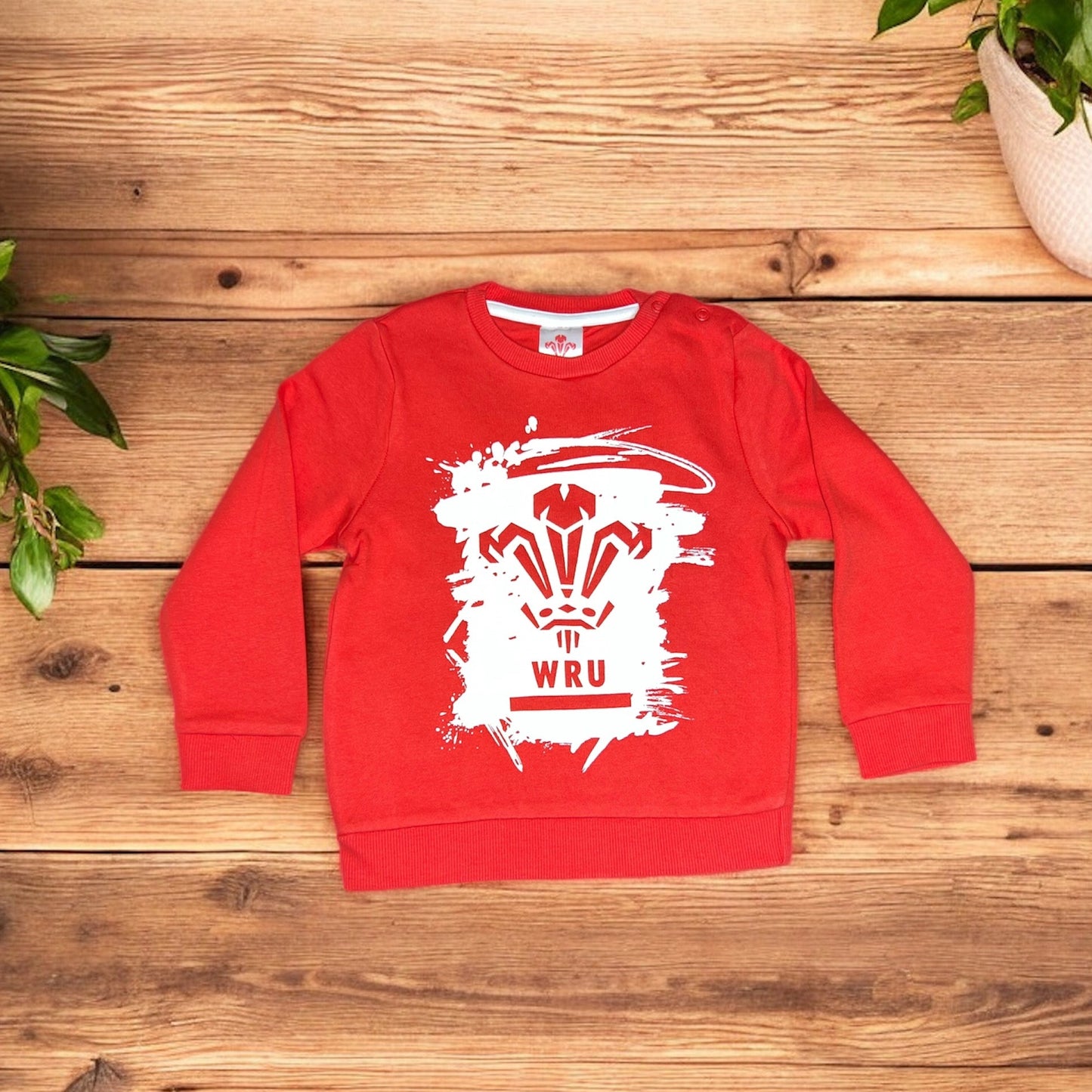 Red Aatiyas Fashion kids sweatshirt with white WRU graphic on wooden background