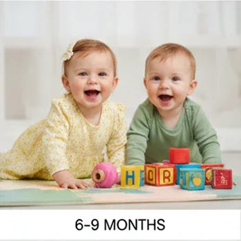 Two infants in Aatiyas Fashion apparel smiling, playing with colorful blocks, 6-9 months age group
