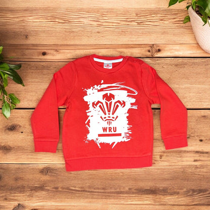 Red Aatiyas Fashion kids sweatshirt with white WRU graphic on wooden background